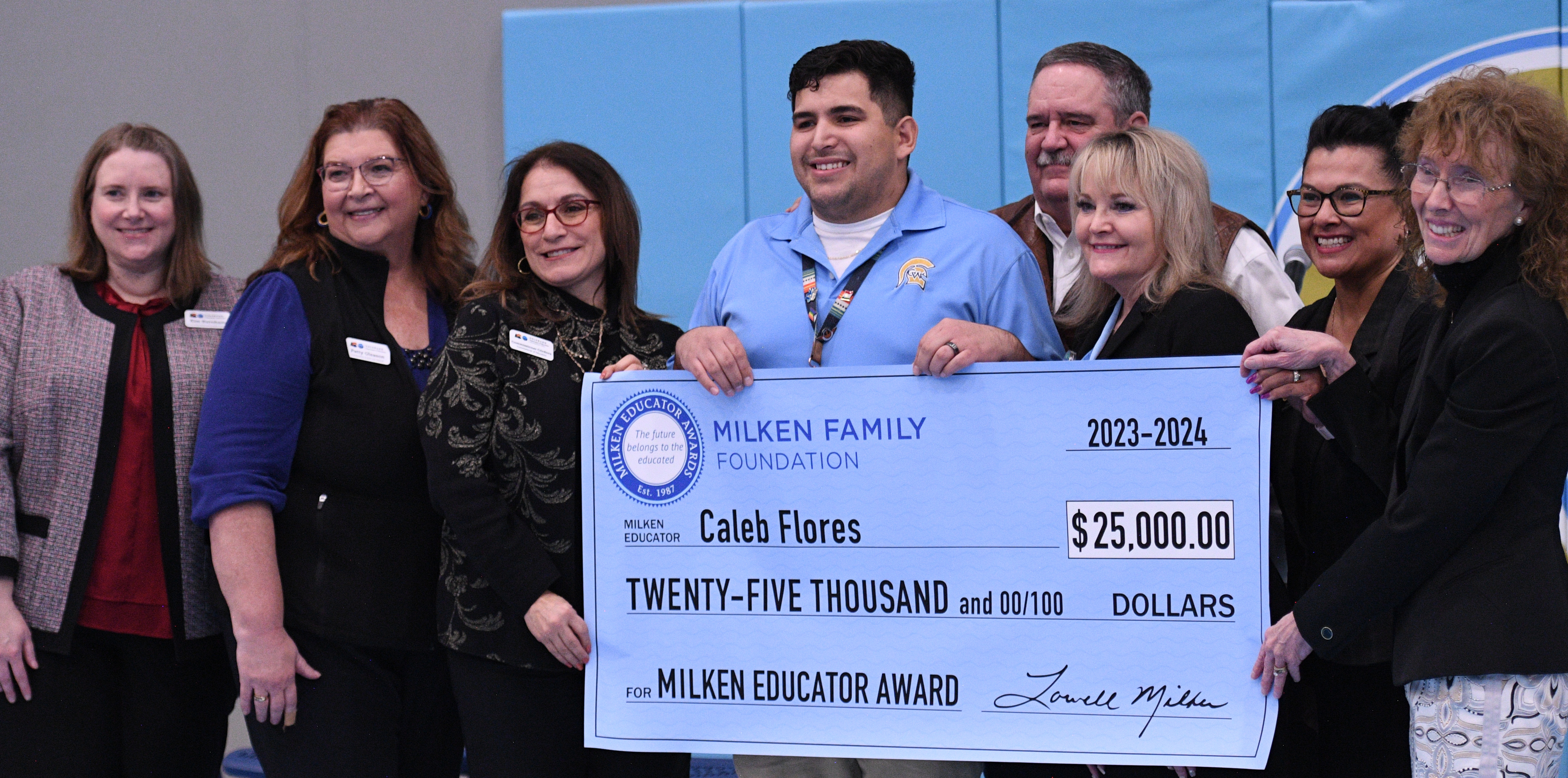 Caleb Flores holding up his big 25,000 check